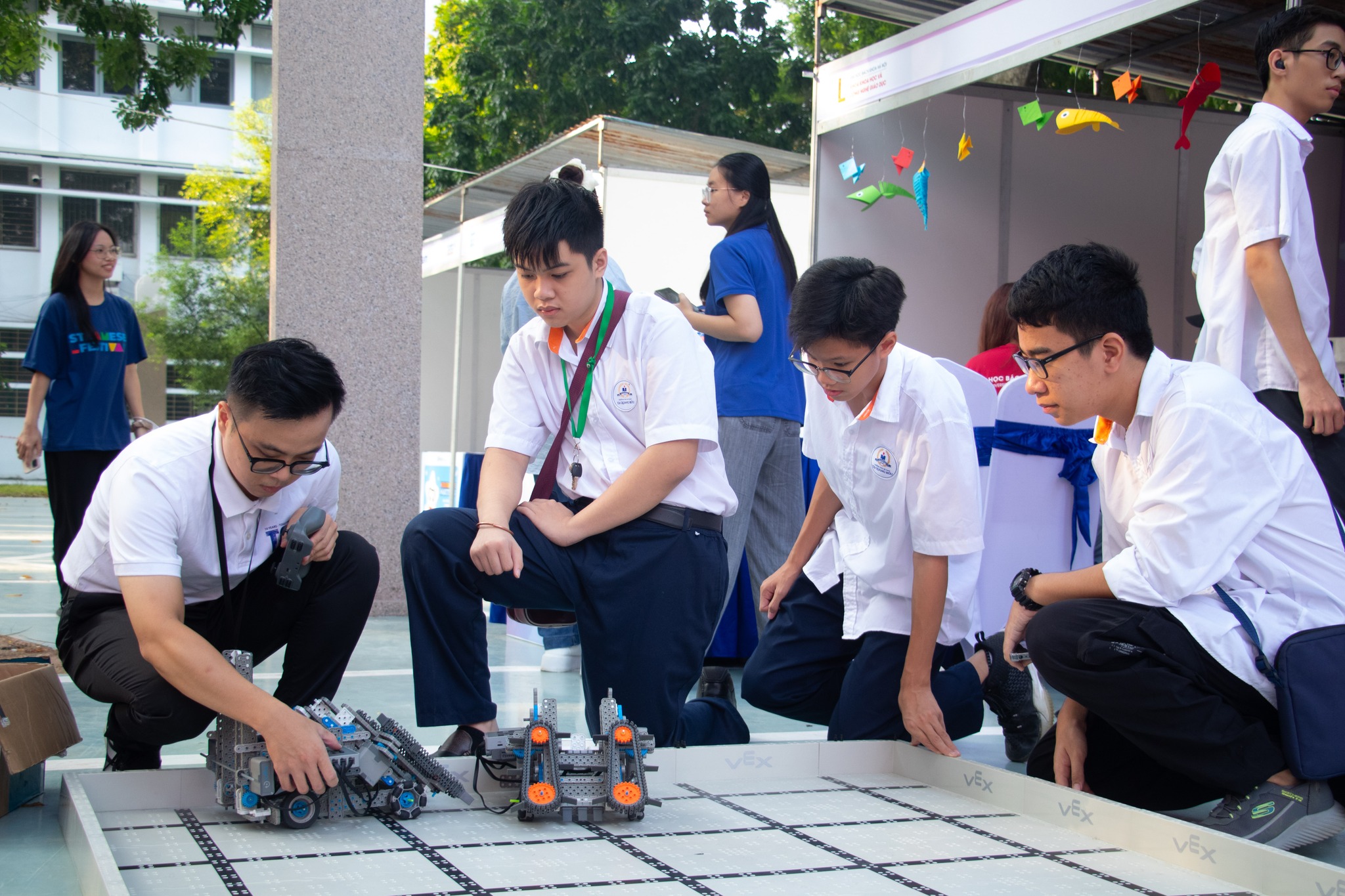 Thầy Quang Linh hướng dẫn học sinh trải nghiệm điều khiển robot.